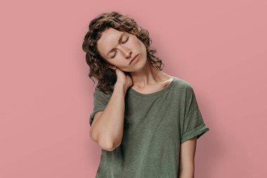 Boyun ağrısından muzdarip yorgun genç bir kadın.