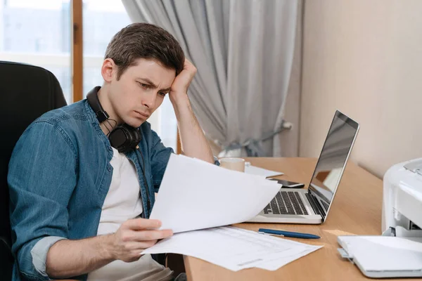 Thoughtful Young Man Sitting Table Laptop Looking Seriously Papers Lost — Stock Photo, Image