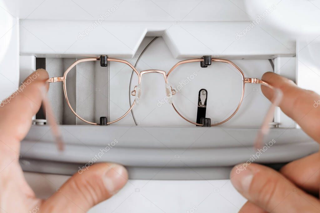 Closeup of glasses lying on table with many temples different color and form. Professional manufacturing and repairing of eyeglasses. Optician measuring and preparing glasses
