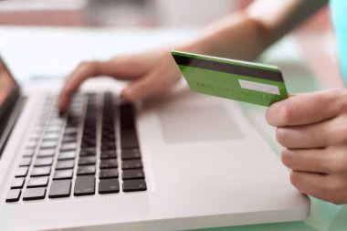 Bilgisayarı kullanarak kredi kartı, e-bankacılık ve e-ticaret konseptiyle online ödemeler yapan bir adamın elleri