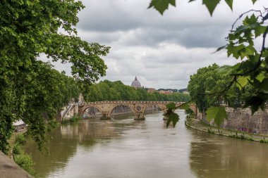 Roma 'da bir köprü ve Vatikan katedrali olan Tiber Nehri manzarası