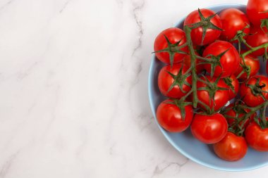 Açık mavi kasede kiraz domateslerinin üst görüntüsü ve metin için kopya alanı