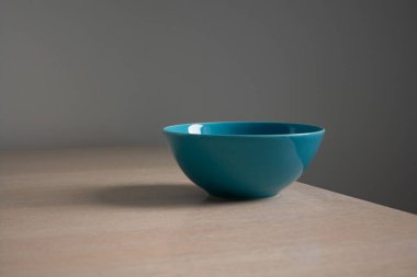 Boş seramik açık mavi kase açık ahşap masada. Minimalizm tarzı kavram