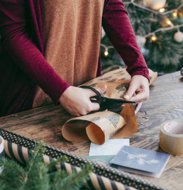 Noel hediyelerini paketleyen kadın.