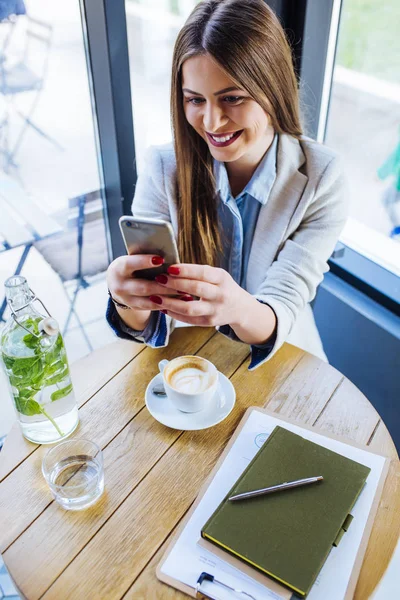 Vacker ung kvinna skriver på sin telefon — Stockfoto