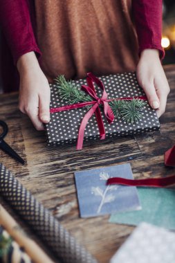 Noel hediyelerini paketleyen kadın.