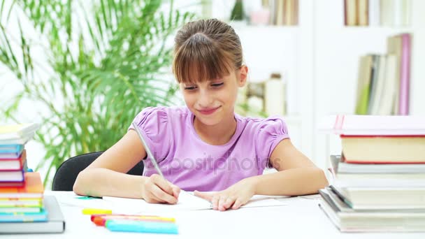 Улыбающаяся девушка делает домашнее задание — стоковое видео