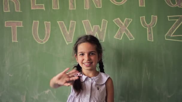 Portret van een lachende Kaukasische schoolmeisje zeggen Hello — Stockvideo