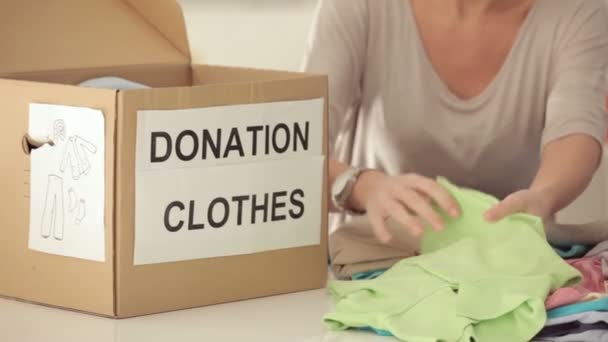 Donna che confeziona vestiti da donare per beneficenza — Video Stock