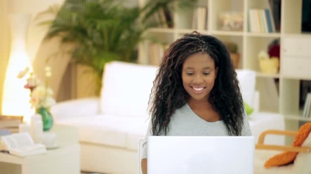 Sonriente chica africana en su computadora portátil — Vídeo de stock