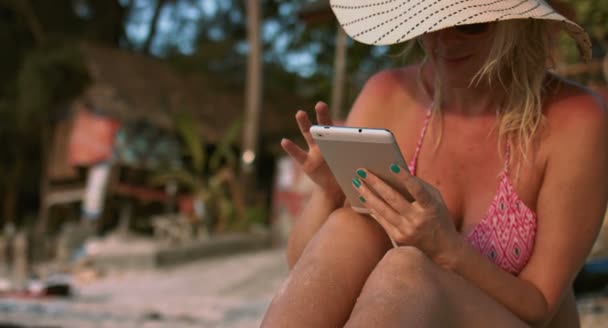 Mujer usando una tableta en la playa — Vídeos de Stock