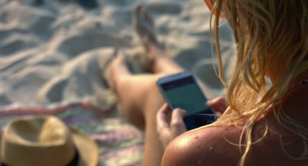 Frau mit Handy am Strand — Stockvideo