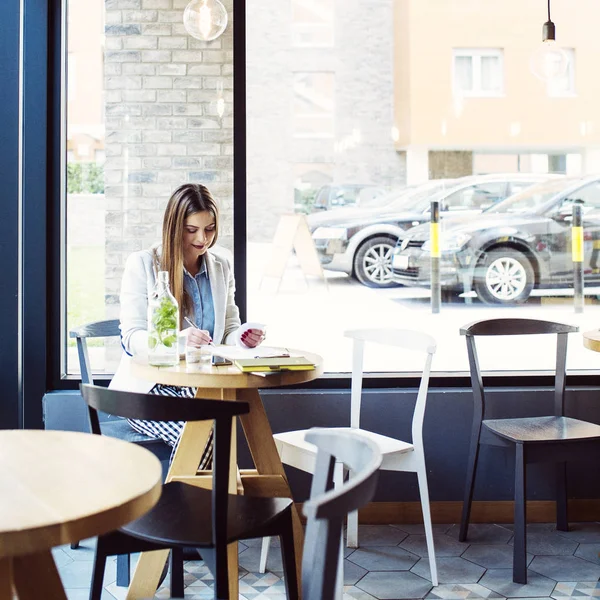 Vacker ung kvinna sitter i Coffee Shop — Stockfoto