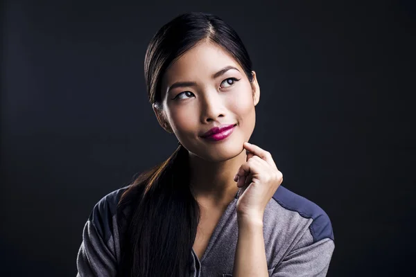Schöne junge asiatische Frau denken — Stockfoto