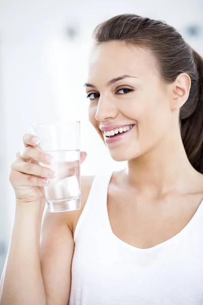 Jonge vrouw met een glas water — Stockfoto