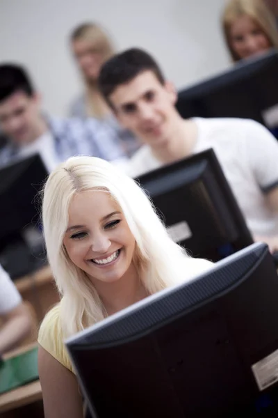 Usmívající se studenti v počítačové učebně — Stock fotografie