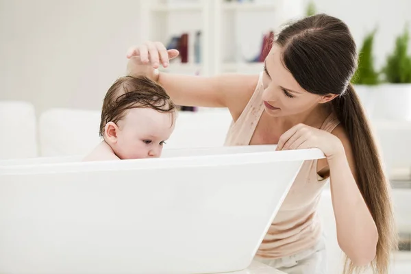 Madre bagnando il suo bambino — Foto Stock