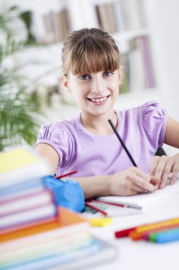 gülümseyen kız ödevini evde yapıyor