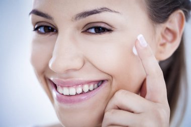 Woman Applying Face Cream clipart