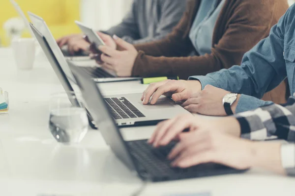 Grupo de personas escribiendo en computadoras portátiles — Foto de Stock