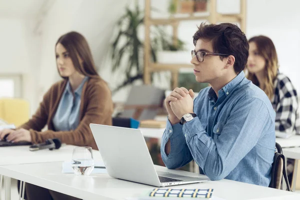 Estudiante universitario sentado en el aula — Foto de Stock