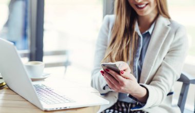 Dizüstü bilgisayarda çalışan ve telefonunuzun ve kadın