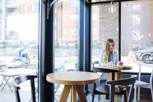 Vacker ung kvinna sitter i Coffee Shop — Stockfoto