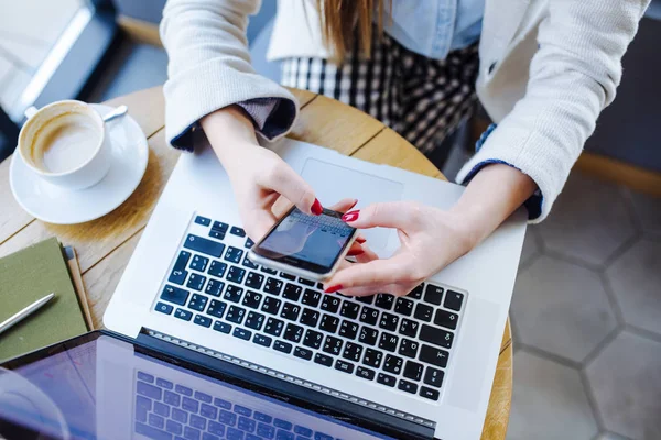 Mulher trabalhando no laptop e usando telefone — Fotografia de Stock