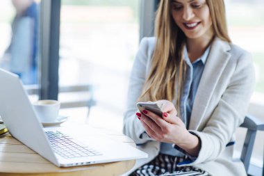 Dizüstü bilgisayarda çalışan ve telefonunuzun ve kadın