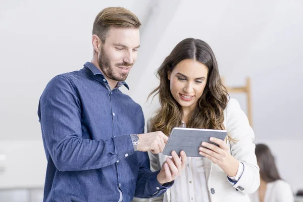 Geschäftsfrau und Geschäftsmann schauen auf Tablet — Stockfoto