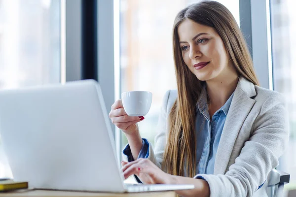 Vacker ung kvinna som arbetar på bärbar dator — Stockfoto