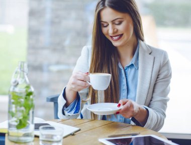 Güzel genç kadın kahve içer