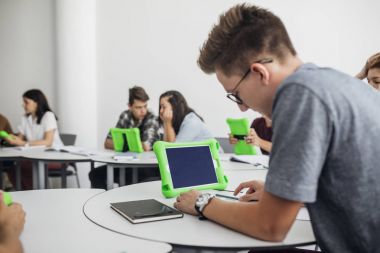 Lise öğrencilerinin yuvarlak sınıfta tablet kullanarak
