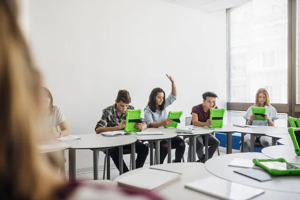 Gymnasieelever med tabletter i runda klassrummet — Stockfoto