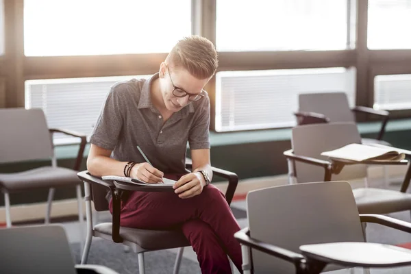 Sorridente studente maschio Prendere appunti — Foto Stock