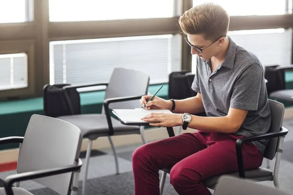 Estudante do sexo masculino tomando notas — Fotografia de Stock