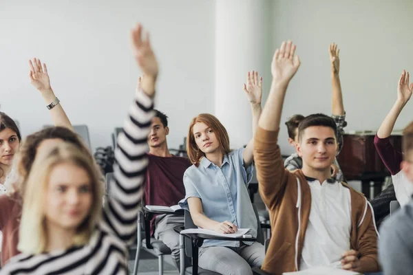 Los estudiantes levantan las manos para responder a la pregunta —  Fotos de Stock