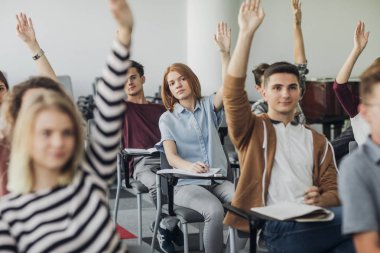 Öğrenci soruyu cevaplamak için eller yükselen