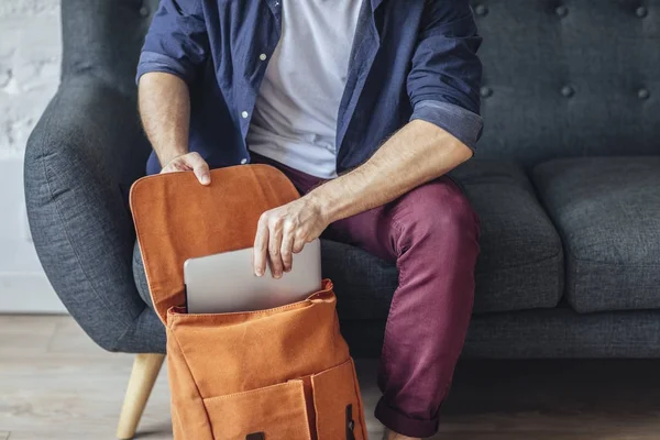 Mann steckt Laptop in Rucksack — Stockfoto