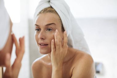 Woman Applying Moisturising Creme on Her Face clipart