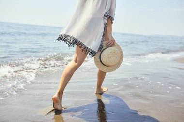 Kumsalda yürüyen bir kadın