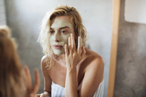 Frau trägt Gesichtsmaske auf — Stockfoto