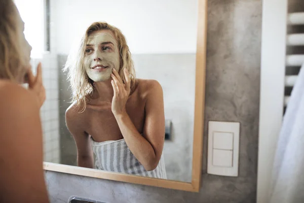 Mulher aplicando máscara facial — Fotografia de Stock