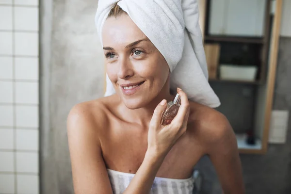 Mujer poniendo perfume en — Foto de Stock