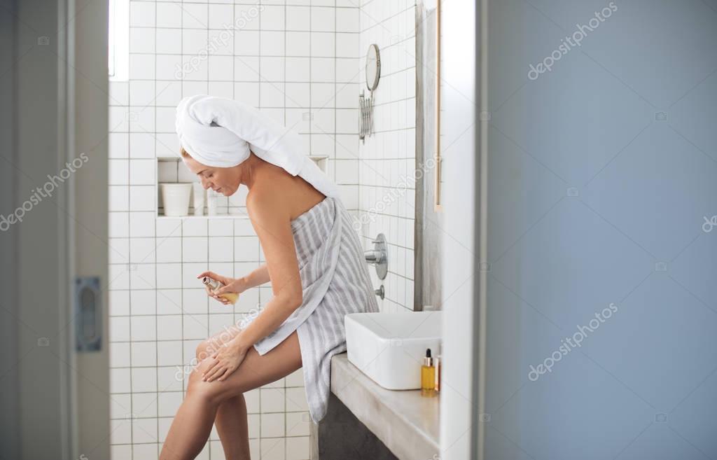 Woman Applying Moisturizer on her Legs