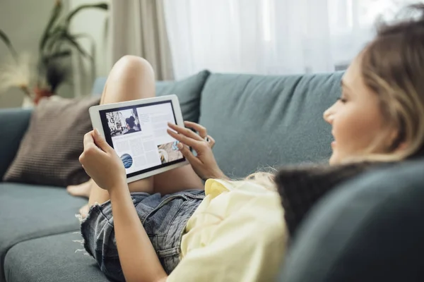 Vrouw Enjoyig tijd thuis en met behulp van Tablet PC — Stockfoto