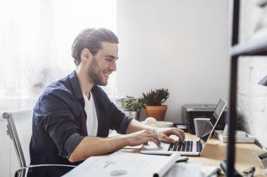 Dizüstü bilgisayarda çalışan adam