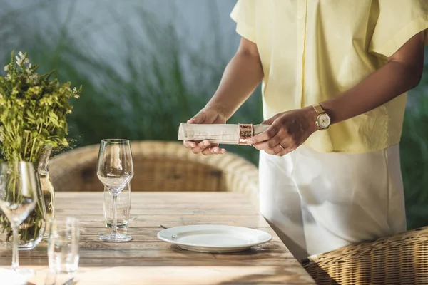 Frau dekoriert Tisch für Dinnerparty im Freien — Stockfoto