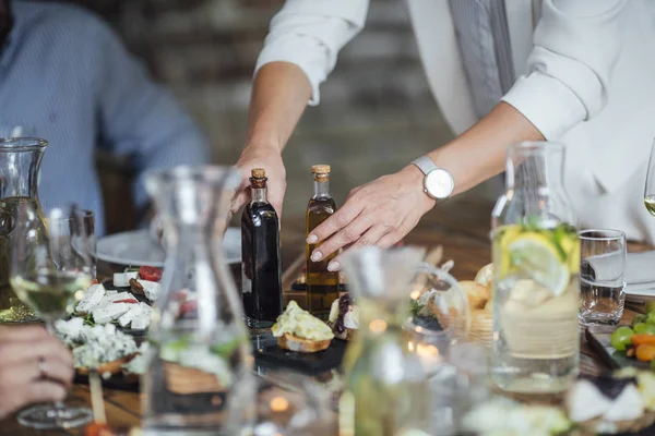 Dîner de femme hôte de fête servant de la nourriture à ses amis — Photo