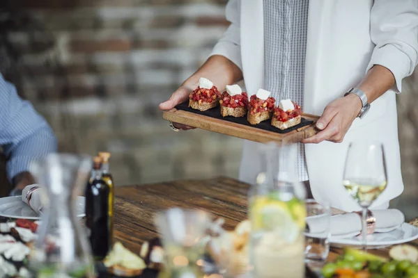 Gastgeberin einer Dinnerparty serviert ihren Freunden Essen — Stockfoto